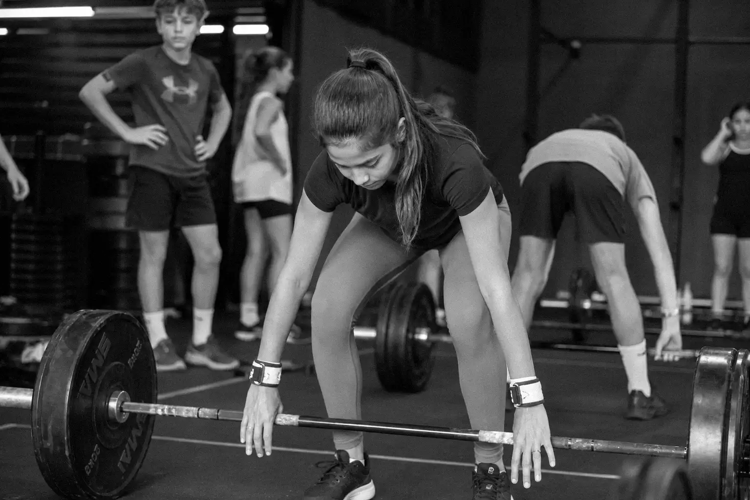A young athlete practising controlled bodyweight movement under a coach's eye at CrossFit Ulladulla