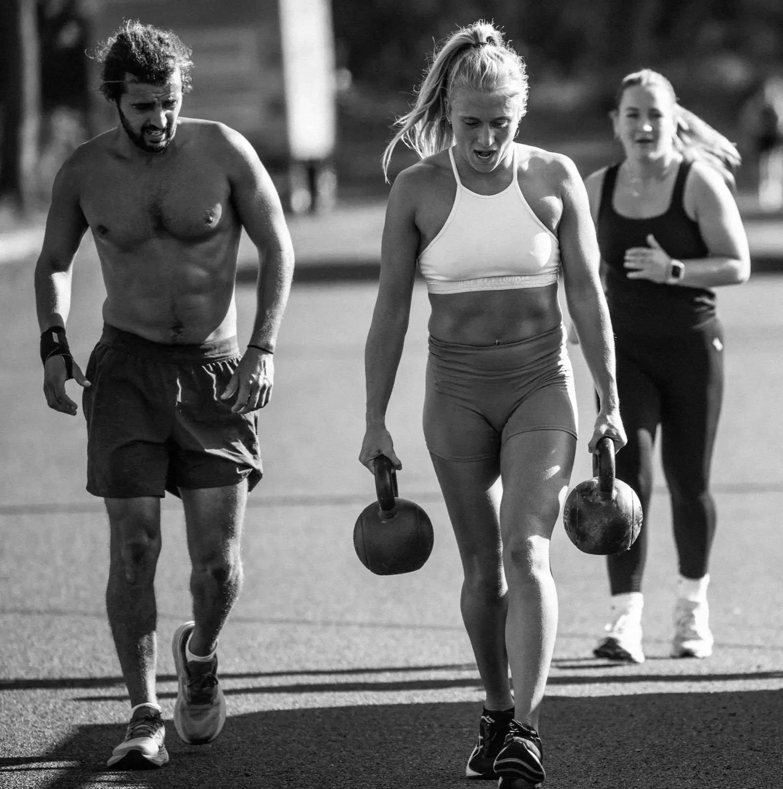 CrossFit Ulladulla members carrying kettlebells together outdoors